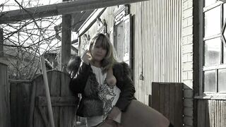 A mature fat milf smokes and shows her tits and pussy in the courtyard of an abandoned house.
